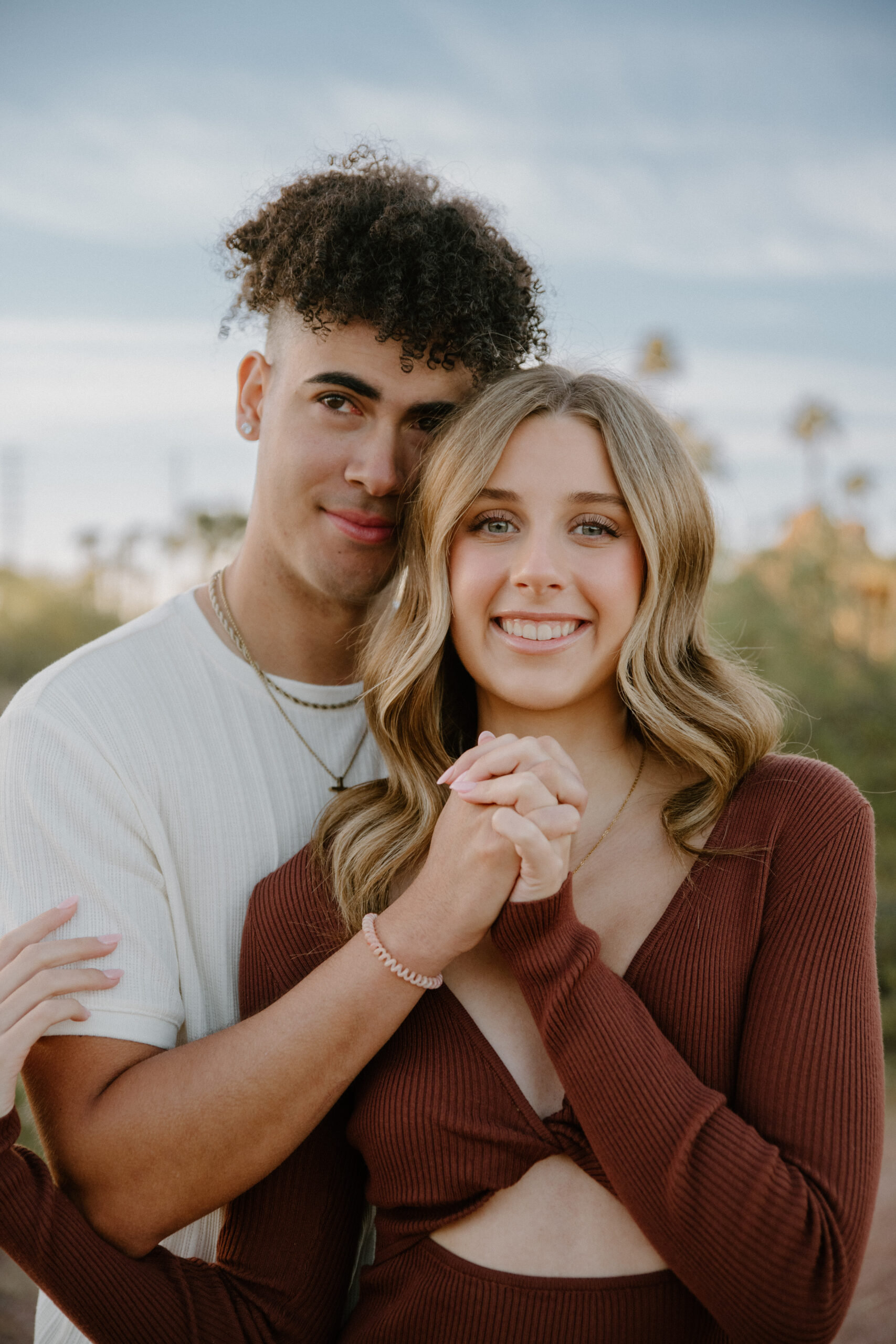 Couple holding hands smiling as they pose for their Arizona engagement photos