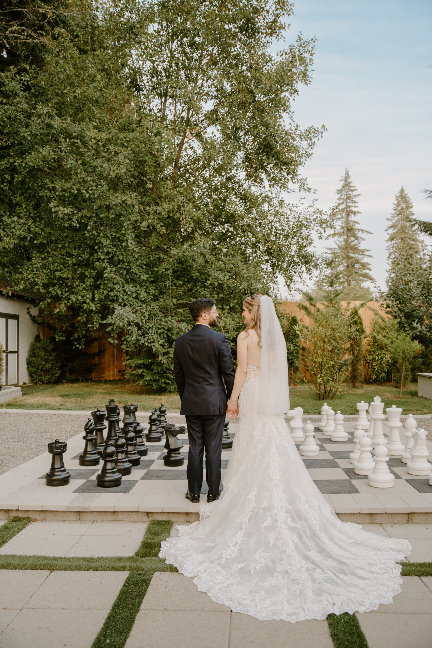 Bride and groom holding hands standing at a chess game