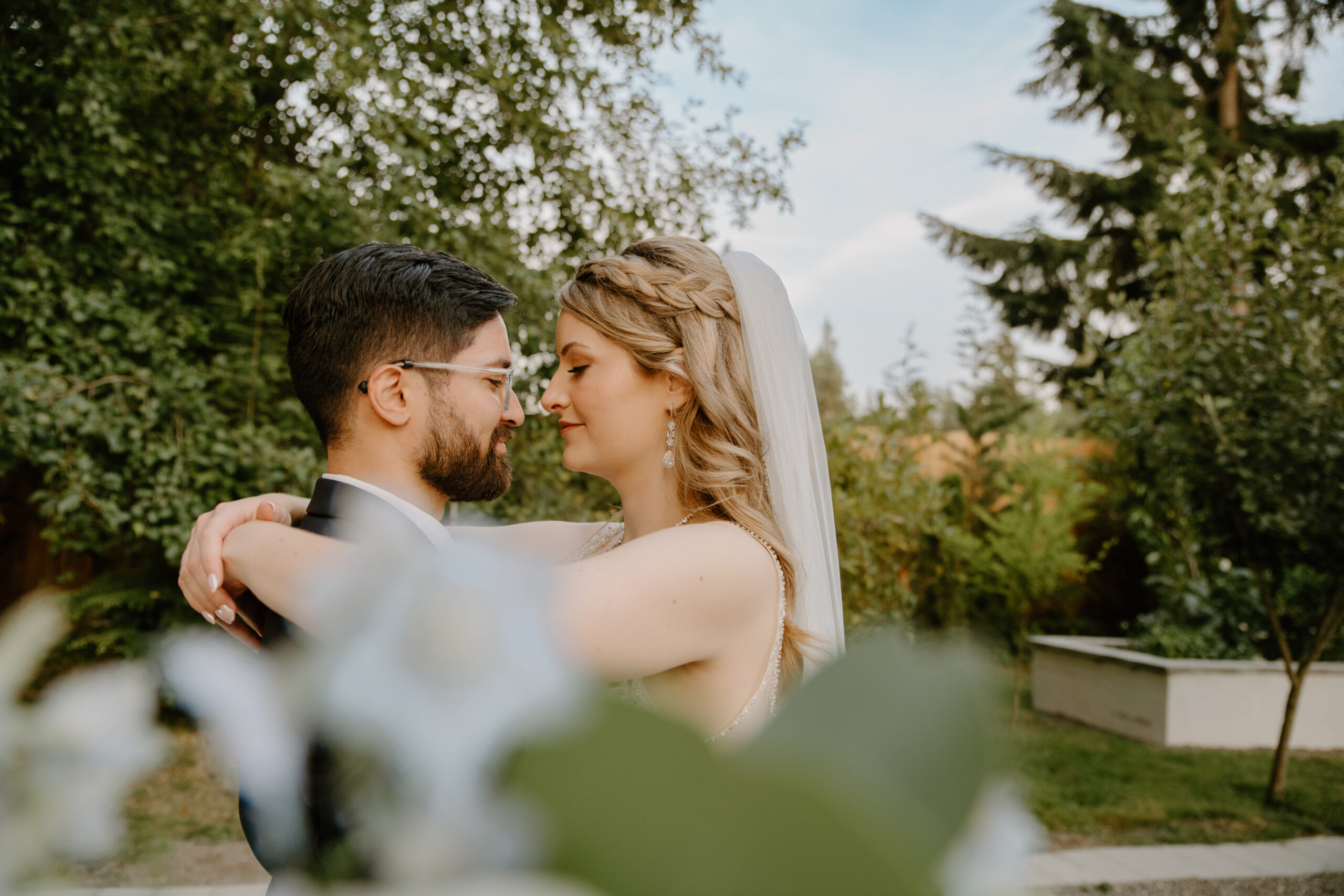 The newlyweds embrace under a softly lit pergola at sunset, surrounded by glowing fairy lights in the romantic garden at Jackson Manor Events.