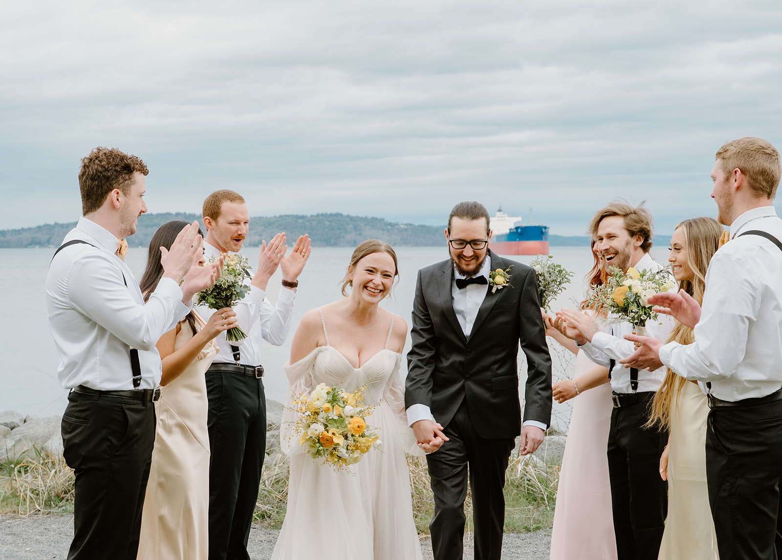 Surrounded by clapping friends, the newlyweds beam with joy after tying the knot at their intimate PNW wedding. 