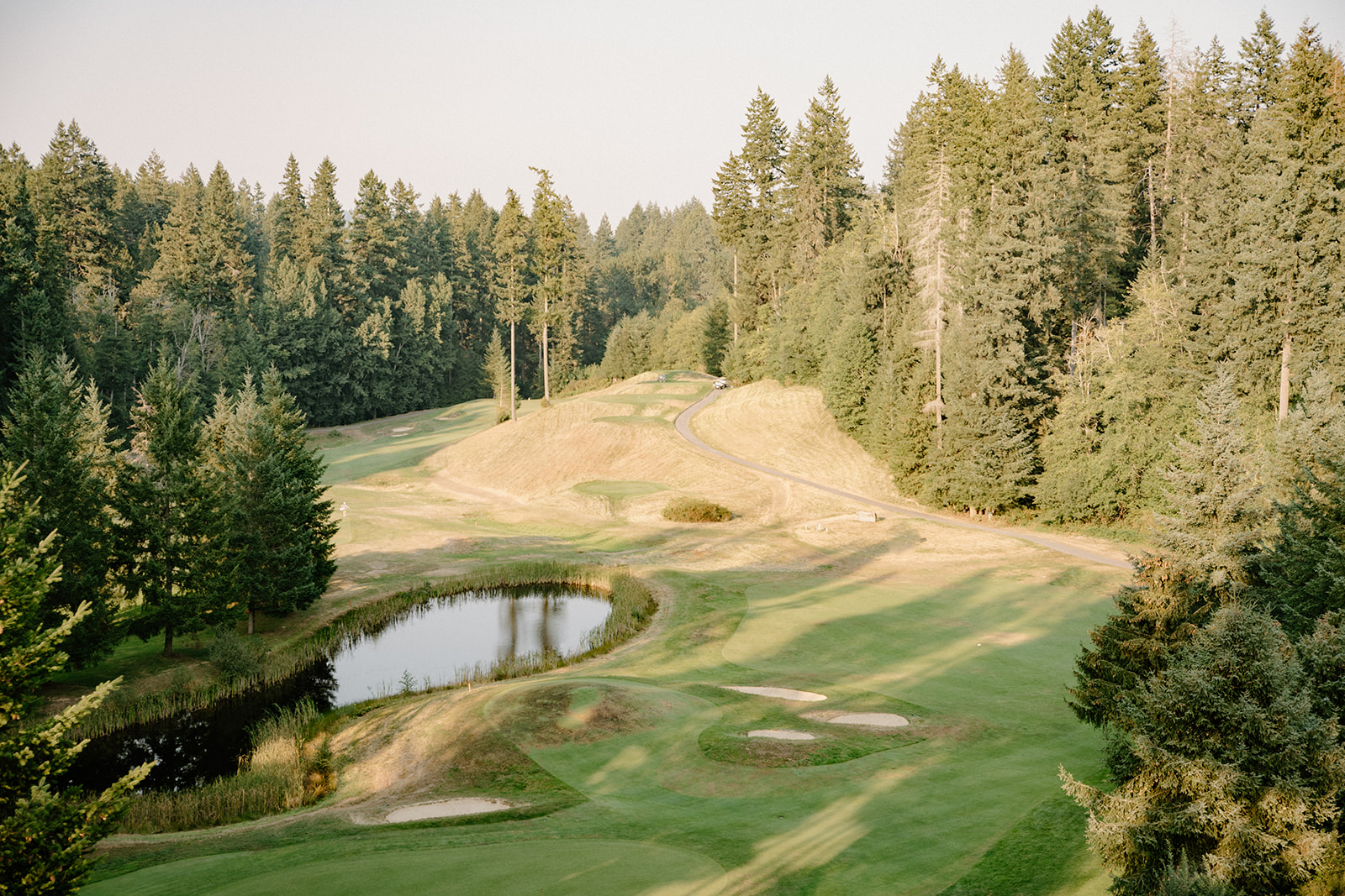 Sunset view of a lush golf course and surrounding forest—a dreamy venue option to consider for your Pacific Northwest wedding planning checklist.