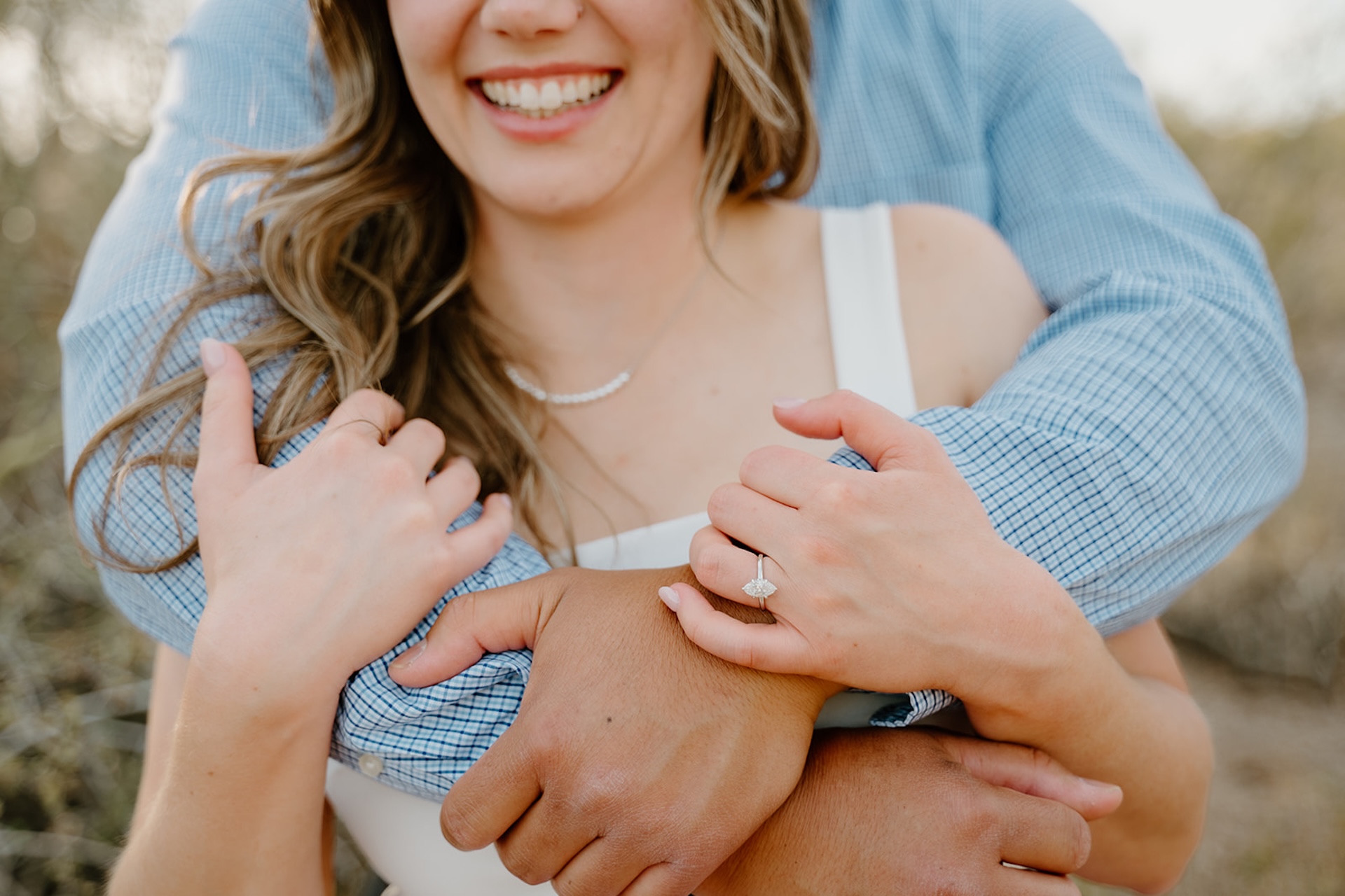 A close-up of the couple laughing together while holding hands on a desert trail, highlighting connection and movement in arizona engagement photos.