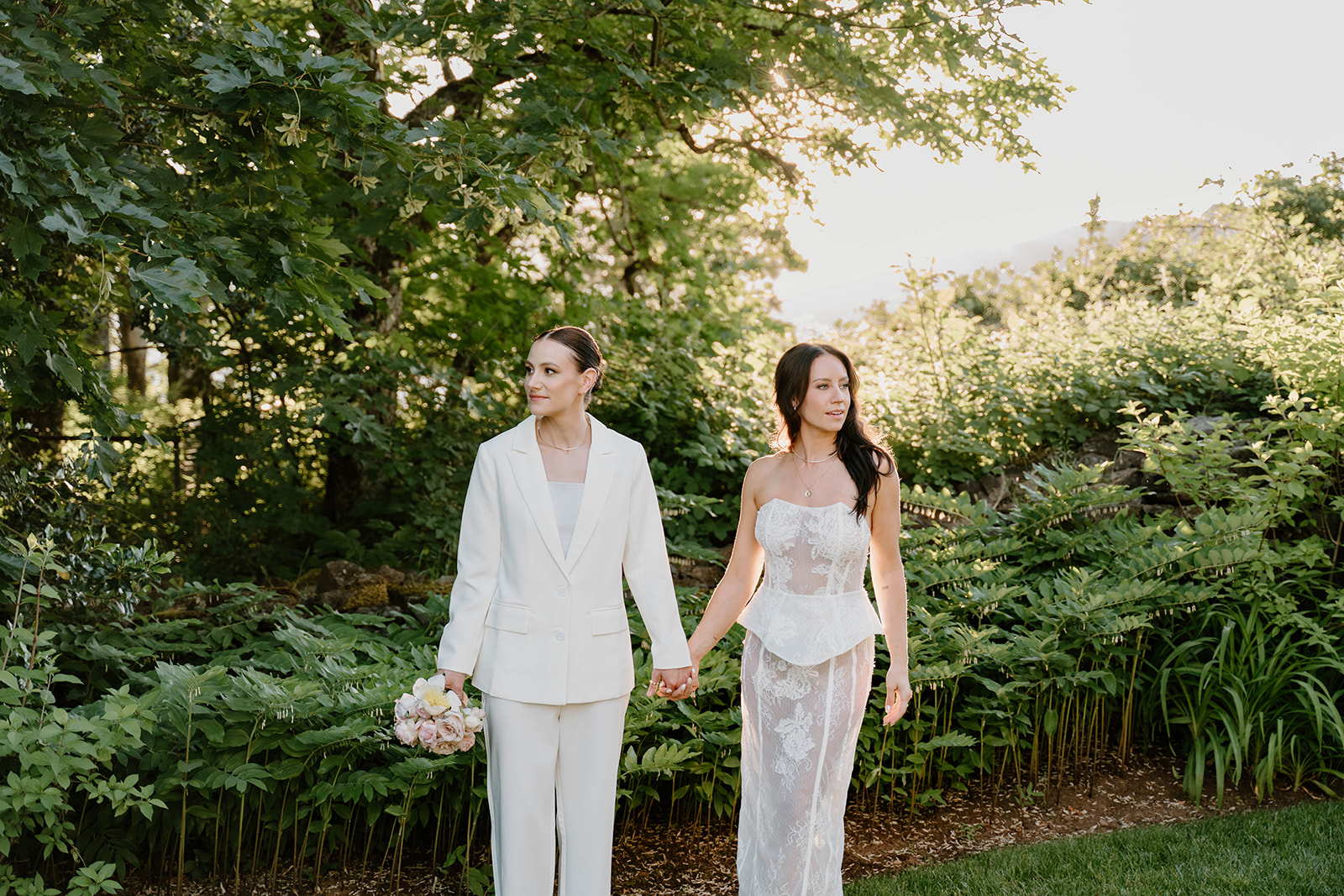An editorial couple photo of the couple holding hands and looking into the distance during their couple portraits at their Griffin House Wedding