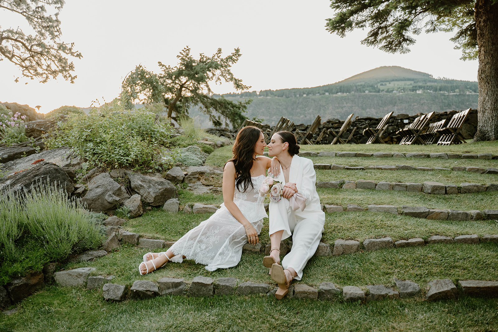 A romantic photo of the newlyweds sitting on the lawn during at sunset for some couple portraits during their Griffin House wedding